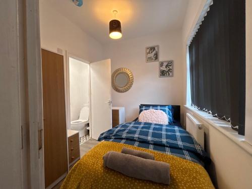 ein Schlafzimmer mit einem blauen Bett und einem Fenster in der Unterkunft Middlesbrough Lodge in Middlesbrough