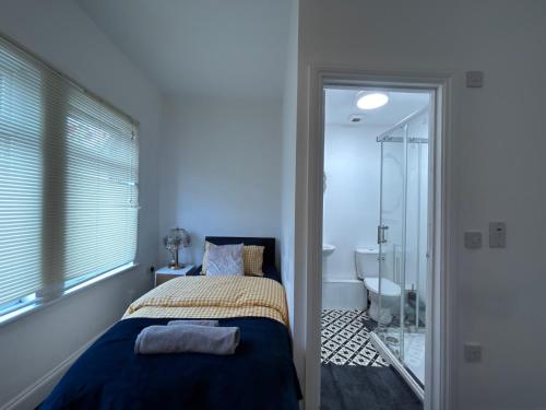 ein Schlafzimmer mit Bett und ein Badezimmer mit Dusche in der Unterkunft Middlesbrough Lodge in Middlesbrough