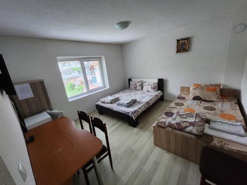 a room with two beds and a table and a desk at Villa BITKOSKI Pestani in Peštani