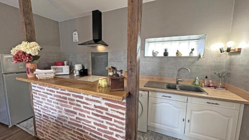 a kitchen with a brick counter and a sink at Chez mémé marie in Rilhac-Lastours