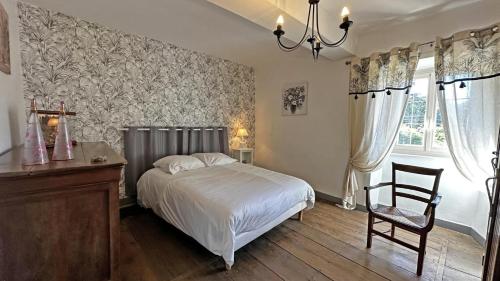 a bedroom with a bed and a desk and a chair at Chez mémé marie in Rilhac-Lastours