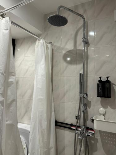 a shower with a shower curtain in a bathroom at Bohemian Chalet in Buşteni