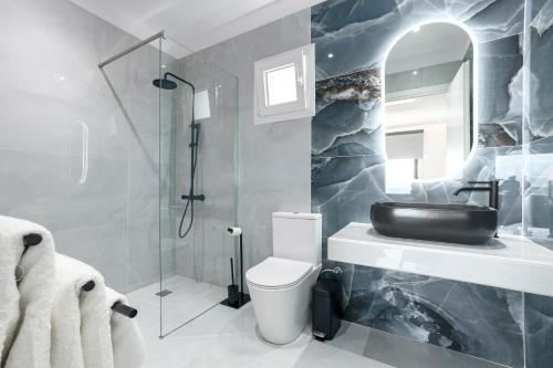 a bathroom with a sink and a toilet and a shower at Skiathos Garden Cottages in Skiathos