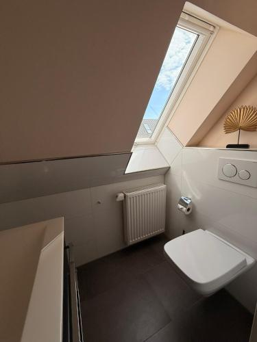 a bathroom with a skylight and a toilet with a window at Villa Fleesenstrand in Göhren-Lebbin