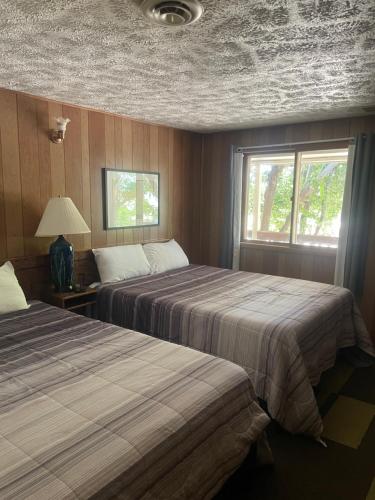 two beds in a room with two windows at Admiral's Cove Resort in Lemoyne