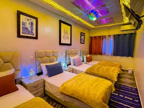 a room with four beds in it with lights at Bluemoon house in Chefchaouen