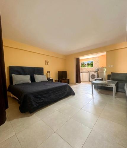 a bedroom with a bed and a living room at Small functional and impeccable loft facing the sea in Douar el Arbi Ben Ahmed