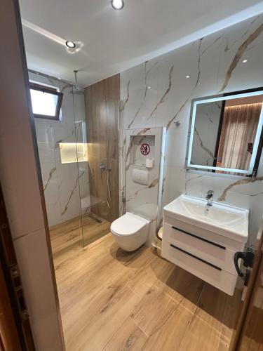 a bathroom with a toilet and a sink and a mirror at Vila Reni Risi in Ksamil
