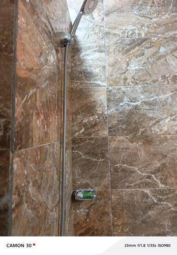 a shower in a bathroom with a glass door at Baie des Anges in Lomé