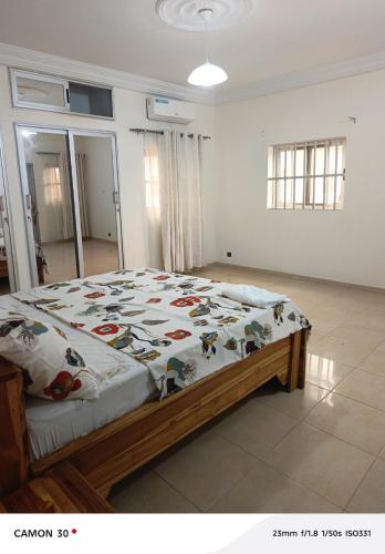 a bedroom with a bed with a comforter on it at Baie des Anges in Lomé