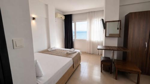 a bedroom with a bed and a desk and a window at Grand Erdek Hotel in Erdek