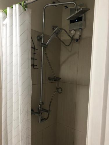 a shower in a bathroom with a shower curtain at Accommodating Place in Manila