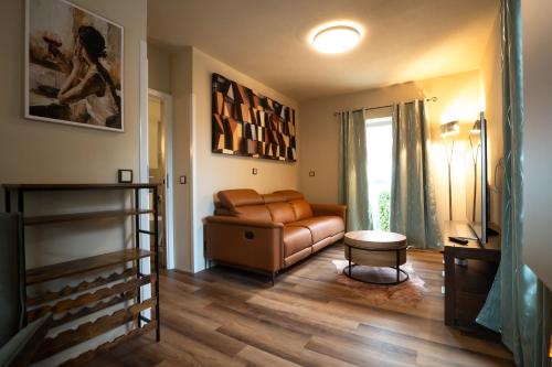 a living room with a leather couch and a table at Spanisches Haus in Staßfurt