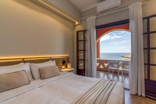 a bedroom with a bed and a view of the ocean at Georgia Vicky Studios & Apartments in Stavros
