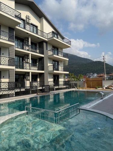 a large swimming pool in front of a building at Fethiye Serenity Suites in Fethiye