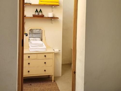 a bathroom with a dresser with a mirror and towels at Mas de Mingall in Les tres Cales