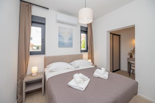 a bedroom with two white towels on a bed at Holiday home Mirage in Sukošan