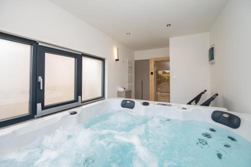 a large bath tub in a room with windows at Holiday home Mirage in Sukošan