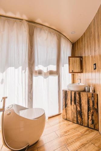 a bathroom with a toilet and a sink and a tub at U Lesa Retreat - Nhà Bên Rừng in Sóc Sơn