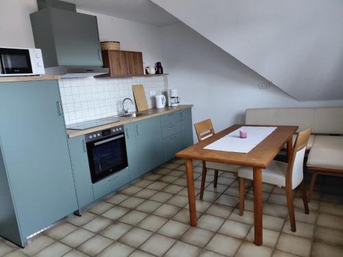 a small kitchen with a wooden table and a table and chairs at Ferienwohnung Knoll in Lähden
