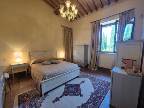 a bedroom with a bed and a chandelier at Agriturismo Camporotondo in Scarlino