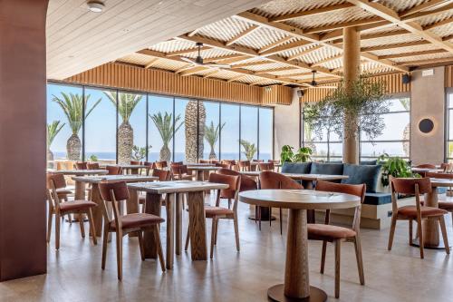 a restaurant with tables and chairs and palm trees at Kakkos Terra Blu Hotel in Ierapetra