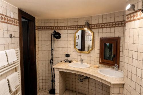 a bathroom with two sinks and a mirror at Hotel Conti Formentini in San Floriano del Cóllio