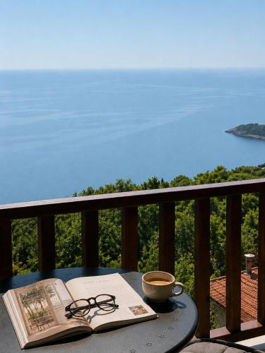 a table with a book and a cup of coffee on a balcony at Om Living Pelion in Agios Dimitrios