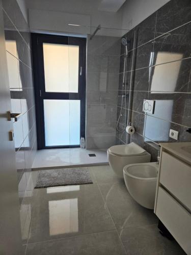 a bathroom with two toilets and a glass door at Sabotino suite in Avezzano