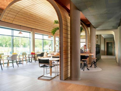 a lobby with tables and chairs in a building at greet hotel Cernay Mulhouse in Cernay