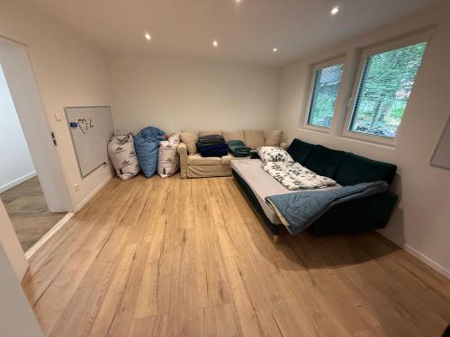 a living room with a couch in a room with wood floors at Chata Produktivne na Jahodniku in Lošonec