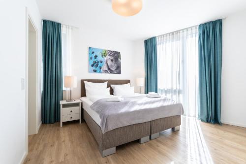 a bedroom with a large bed with green curtains at Südkap C-02 in Pelzerhaken