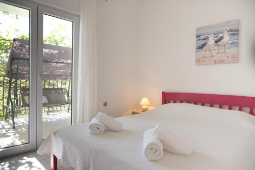 a bedroom with a white bed with towels on it at Robinson Ilijana in Gdinj