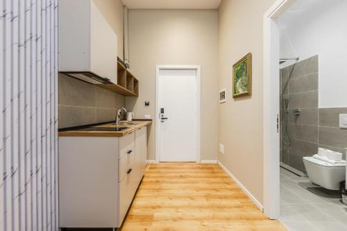 a small kitchen with a sink and a toilet at Palm Beachfront Suites by PS in Durrës