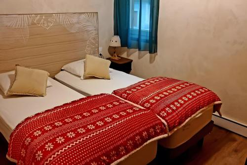 a bedroom with a bed with a red blanket at Gentiane 7 pers - proche pistes in Châtel