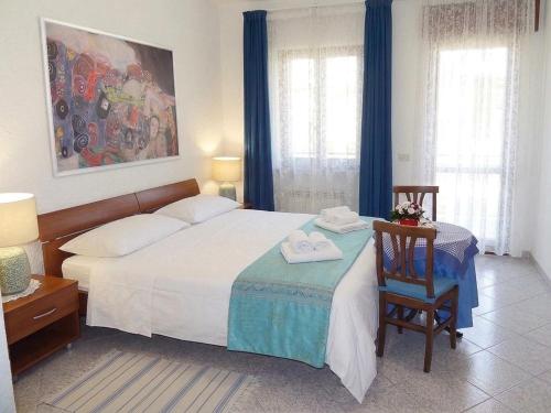 a bedroom with a bed with a chair and a table at Apartments Ruby in Funtana