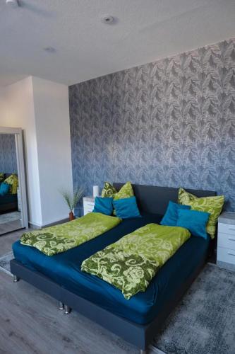 a bedroom with a blue bed with green sheets and blue pillows at Ingrid in Schwarzatal