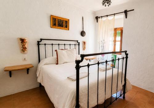 a bedroom with a bed in a room with a window at Cortijo La Gineta in Alcalá la Real