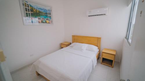 a bedroom with a bed and a picture on the wall at Familiar 5 piso in Coveñas