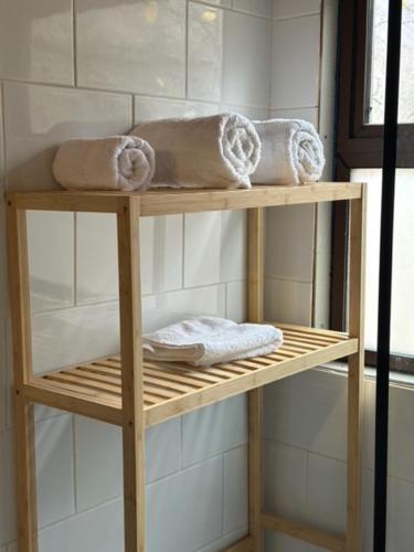 a wooden shelf with towels on it in a bathroom at Hostal Piolet en Baños Morales in San José de Maipo