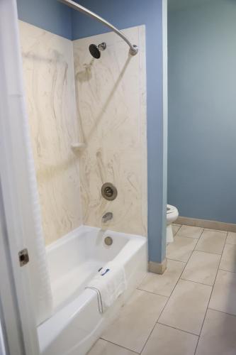 a bathroom with a shower and a white tub at Black Gold Inn in Yoakum