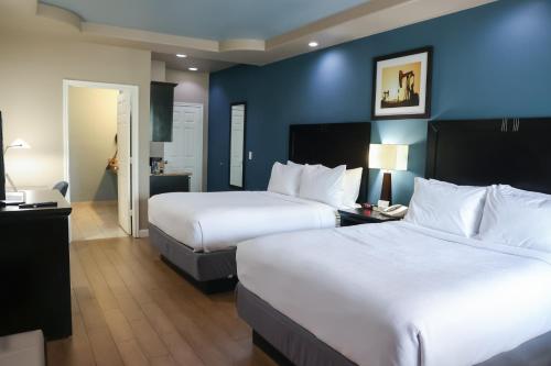 a hotel room with two beds and a blue wall at Black Gold Inn in Yoakum