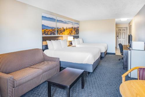 a hotel room with a bed and a couch at Days Inn by Wyndham Waynesville NC in Waynesville