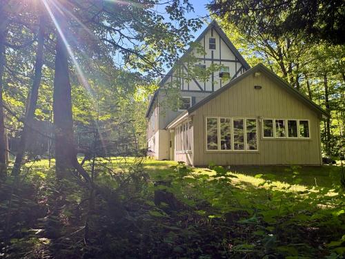 a house in the middle of a yard with trees at Creekside Chalet - Huge Indoor Spa in Bessemer