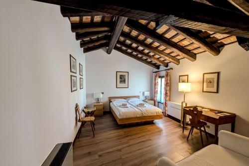 a bedroom with a bed and a desk in a room at Hotel Conti Formentini in San Floriano del Cóllio