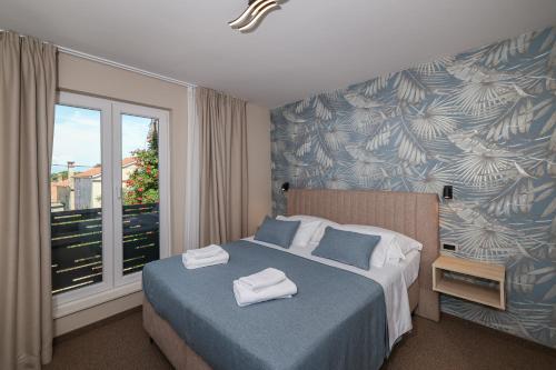 a bedroom with a bed with two towels on it at Rooms Sorićev Dvor in Preko