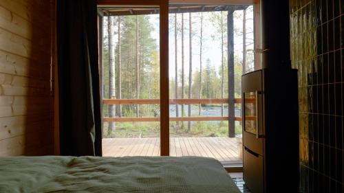 a bedroom with a large glass door to a deck at Aurakoski 1 in Ranua