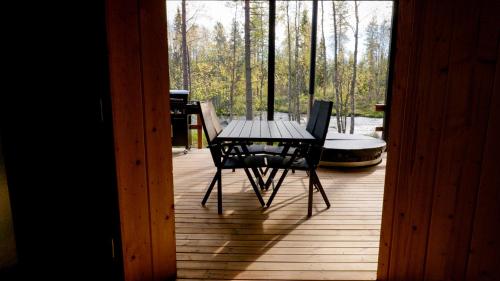 a table and chairs on a deck with a tub at Aurakoski 1 in Ranua