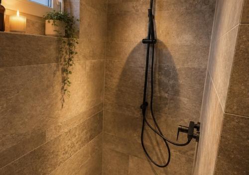 a shower with a hose in a bathroom at Erftlodges L2 in Bad Münstereifel