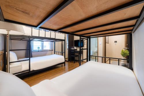 a bedroom with two beds and a desk at Soosong Guesthouse Gwanghwamun Myeongdon g in Seoul